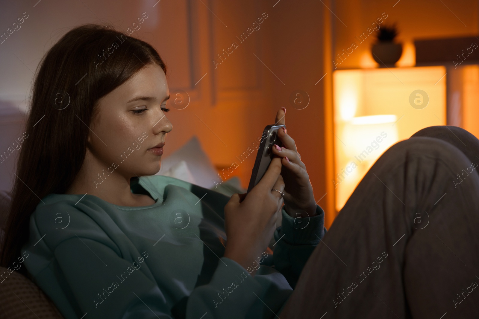 Beautiful teenage girl using smartphone at home Photo of Beautiful teenage girl using smartphone at home