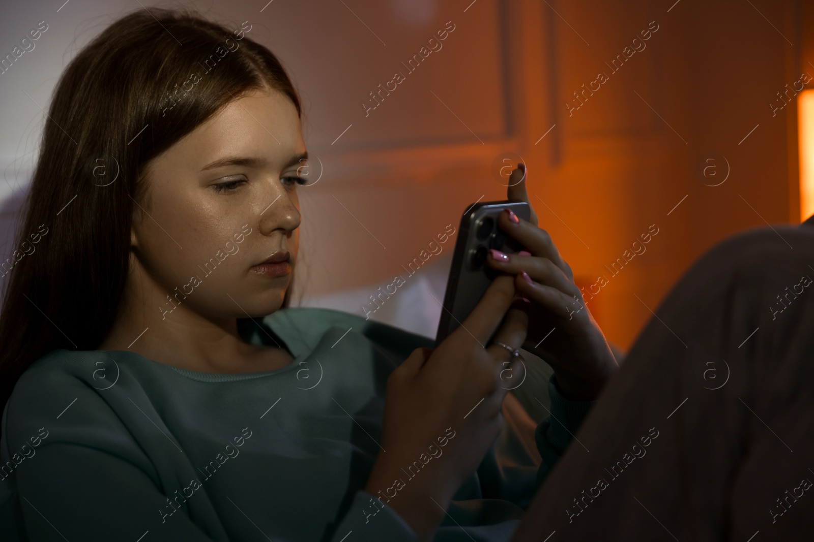 Beautiful teenage girl using smartphone at home Photo of Beautiful teenage girl using smartphone at home