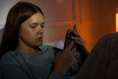 Photo of Beautiful teenage girl using smartphone at home