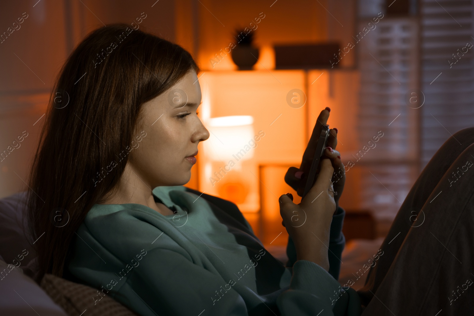 Beautiful teenage girl using smartphone at home Photo of Beautiful teenage girl using smartphone at home