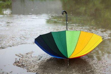 Photo of Colorful umbrella on wet asphalt under heavy rain. Space for text
