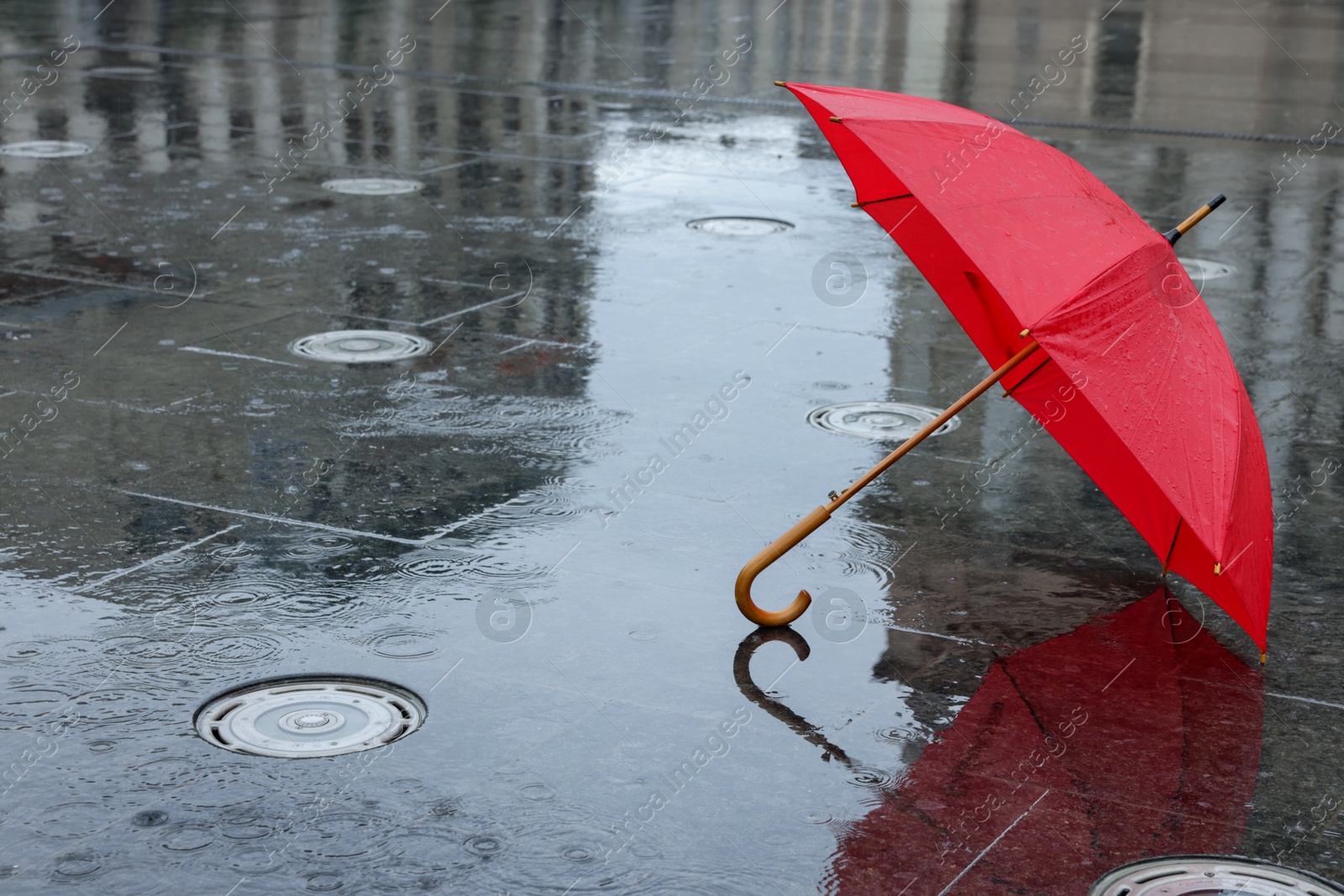 Red umbrella under heavy rain outdoors, space for text Photo of Red umbrella under heavy rain outdoors, space for text