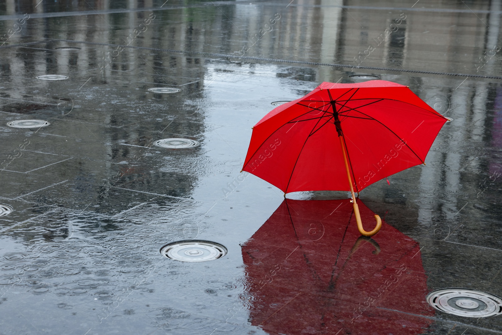 Red umbrella under heavy rain outdoors, space for text Photo of Red umbrella under heavy rain outdoors, space for text
