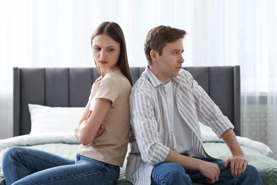 Photo of Woman and man having quarrel on bed at home
