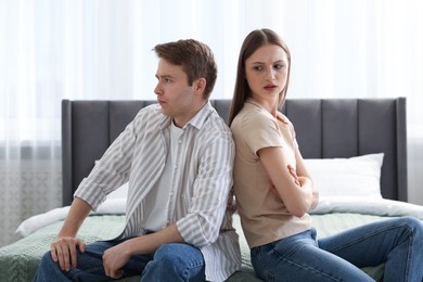 Photo of Woman and man having quarrel on bed at home