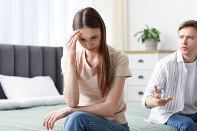 Photo of Woman and man fighting on bed at home, selective focus