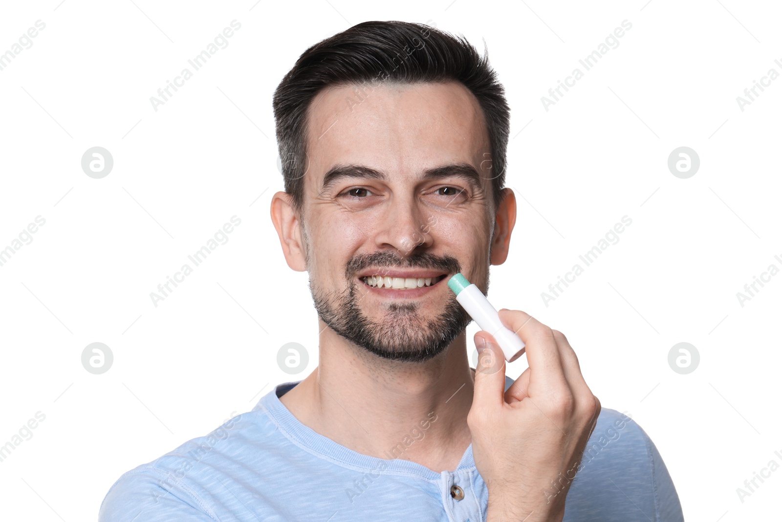 Smiling man applying lip balm onto his lips on white background Photo of Smiling man applying lip balm onto his lips on white background