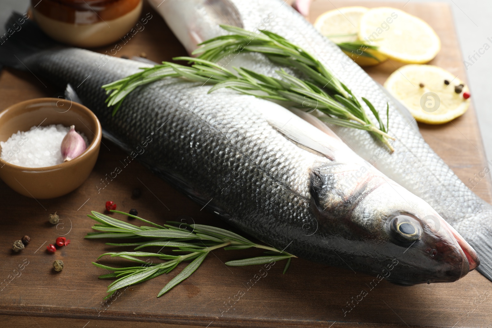 Fresh raw seabass with spices on table, closeup. Fish and seafood delicacies Photo of Fresh raw seabass with spices on table, closeup. Fish and seafood delicacies