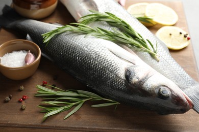 Photo of Fresh raw seabass with spices on table, closeup. Fish and seafood delicacies