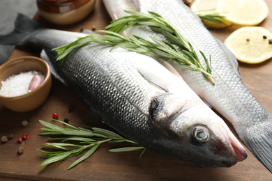 Photo of Fresh raw seabass with spices on table, closeup. Fish and seafood delicacies