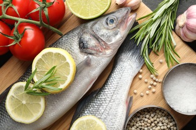 Photo of Fresh raw seabass with spices on table, closeup. Fish and seafood delicacies