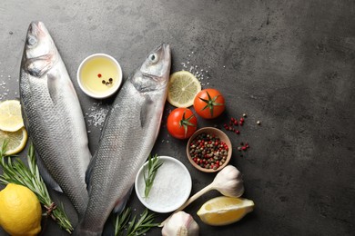Photo of Fresh raw seabass fish with spices on grey table, flat lay and space for text. Seafood delicacies