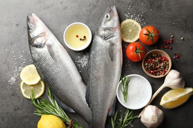 Photo of Fresh raw seabass with spices on grey table, flat lay. Fish and seafood delicacies