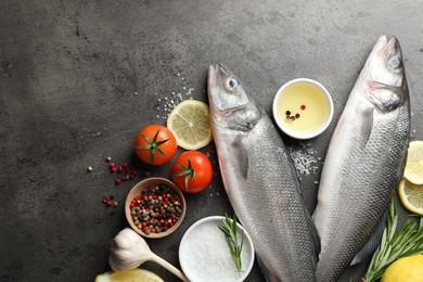 Photo of Fresh raw seabass fish with spices on grey table, flat lay and space for text. Seafood delicacies