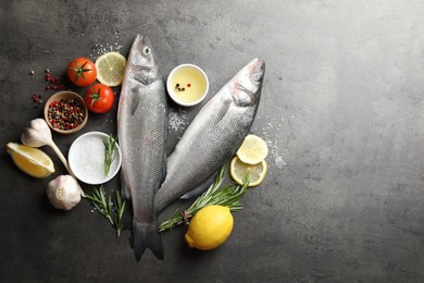 Photo of Fresh raw seabass fish with spices on grey table, flat lay and space for text. Seafood delicacies