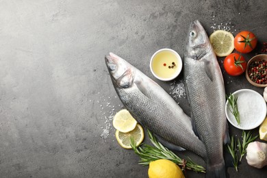Photo of Fresh raw seabass fish with spices on grey table, flat lay and space for text. Seafood delicacies