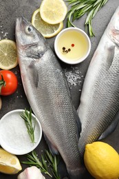 Photo of Fresh raw seabass with spices on grey table, flat lay. Fish and seafood delicacies