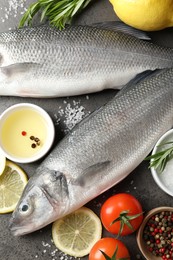 Photo of Fresh raw seabass with spices on grey table, closeup. Fish and seafood delicacies