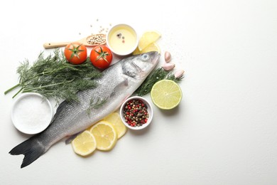 Photo of Fresh raw seabass fish with spices on white table, flat lay and space for text. Seafood delicacies