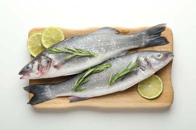 Photo of Fresh raw seabass with spices on white table, top view. Fish and seafood delicacies