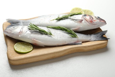Photo of Fresh raw seabass with spices on white table, closeup. Fish and seafood delicacies