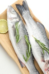 Photo of Fresh raw seabass with spices on white table, top view. Fish and seafood delicacies