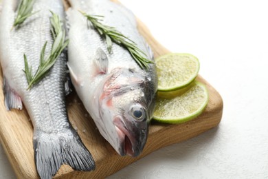 Photo of Fresh raw seabass with spices on white table, closeup. Fish and seafood delicacies