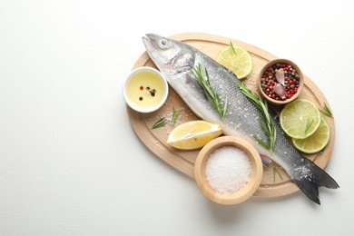 Photo of Fresh raw seabass fish with spices on white table, top view and space for text. Seafood delicacies