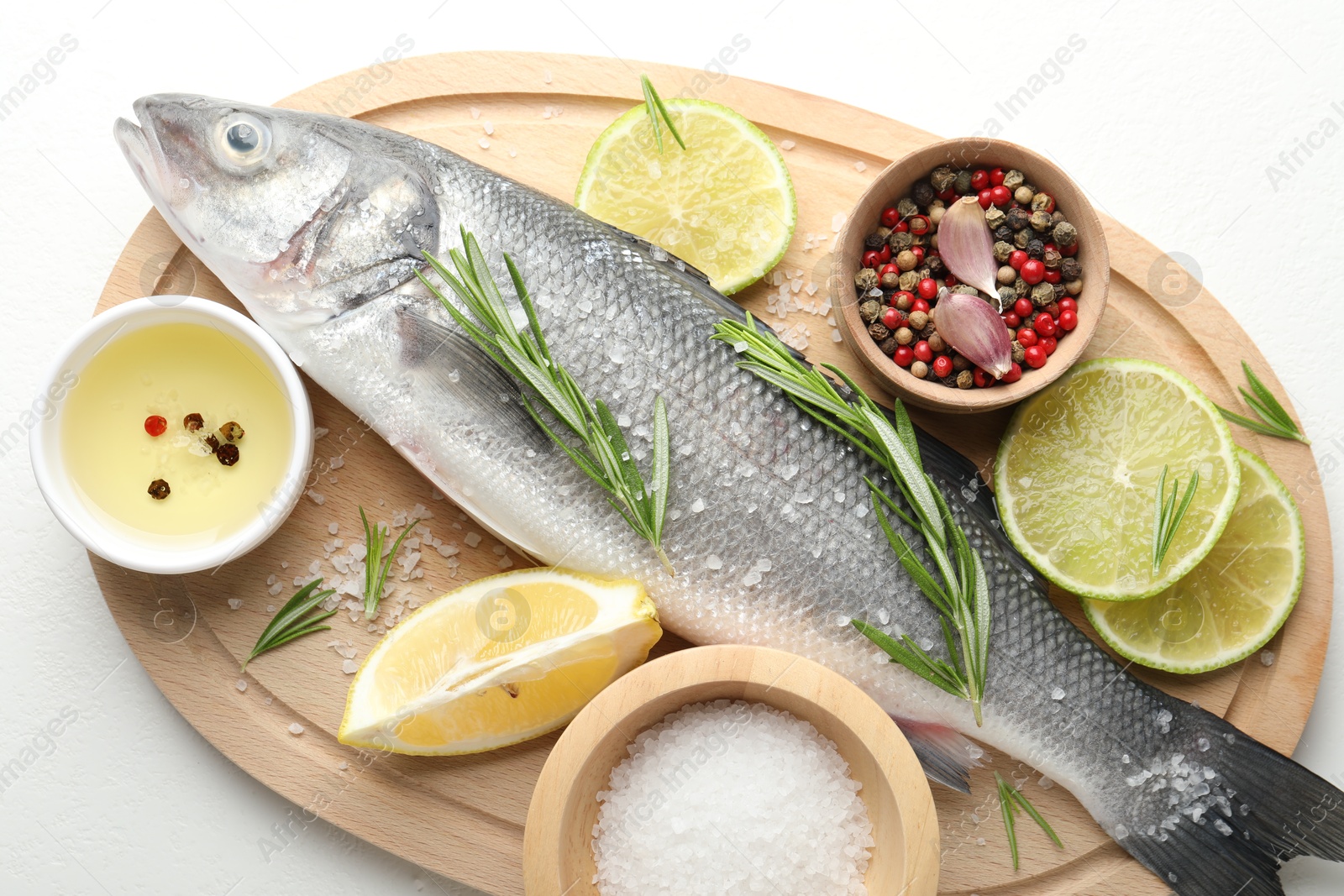 Fresh raw seabass with spices on white table, top view. Fish and seafood delicacies Photo of Fresh raw seabass with spices on white table, top view. Fish and seafood delicacies