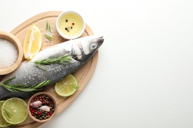 Photo of Fresh raw seabass fish with spices on white table, top view and space for text. Seafood delicacies
