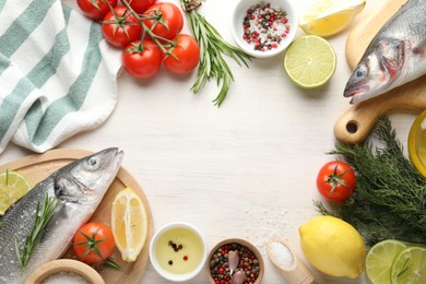 Photo of Frame of fresh raw seabass fish with spices on white wooden table, flat lay and space for text. Seafood delicacies
