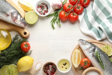 Photo of Frame of fresh raw seabass fish with spices on white wooden table, flat lay and space for text. Seafood delicacies