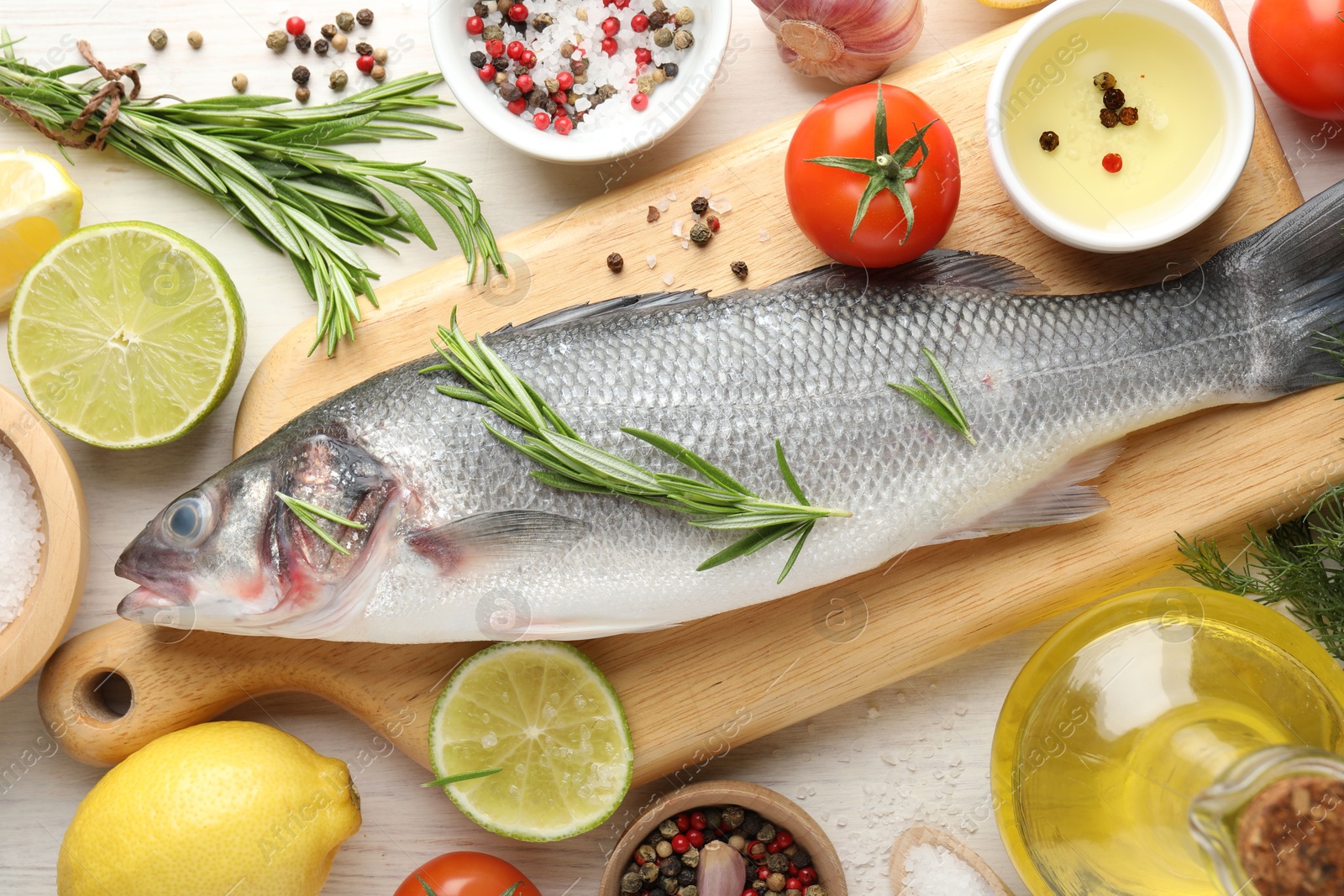 Fresh raw seabass with spices on white wooden table, flat lay. Fish and seafood delicacies Photo of Fresh raw seabass with spices on white wooden table, flat lay. Fish and seafood delicacies