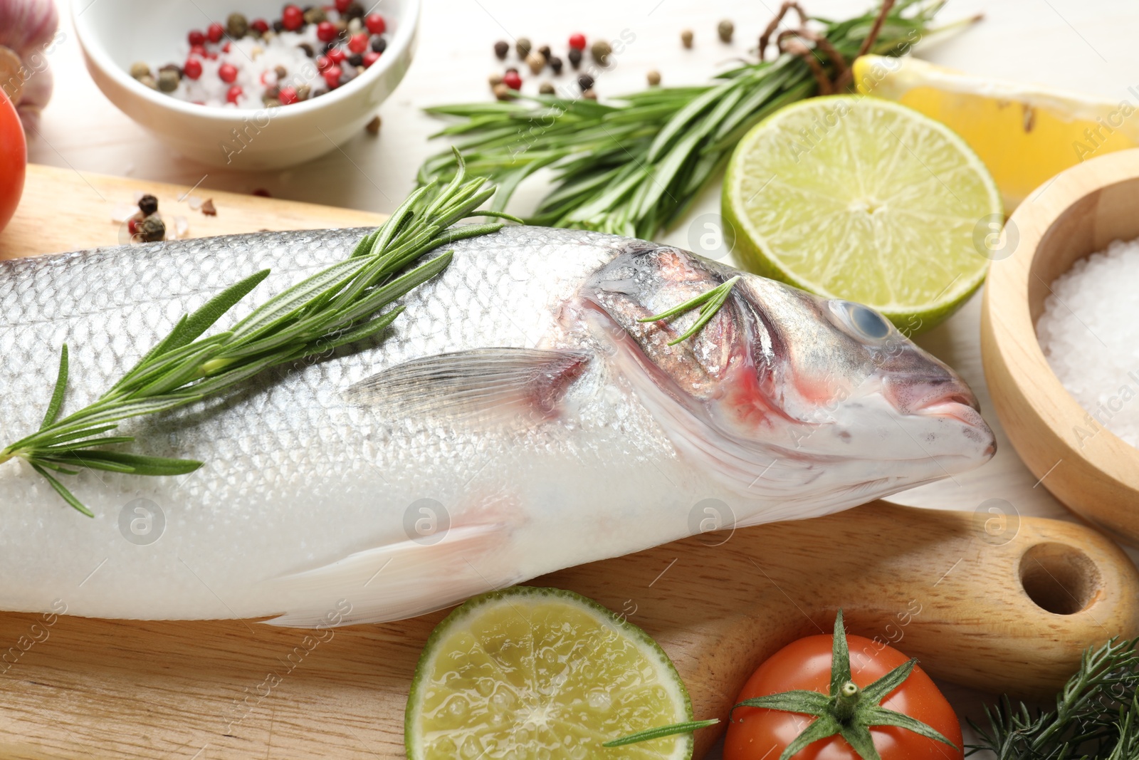 Fresh raw seabass with spices on white wooden table, closeup. Fish and seafood delicacies Photo of Fresh raw seabass with spices on white wooden table, closeup. Fish and seafood delicacies