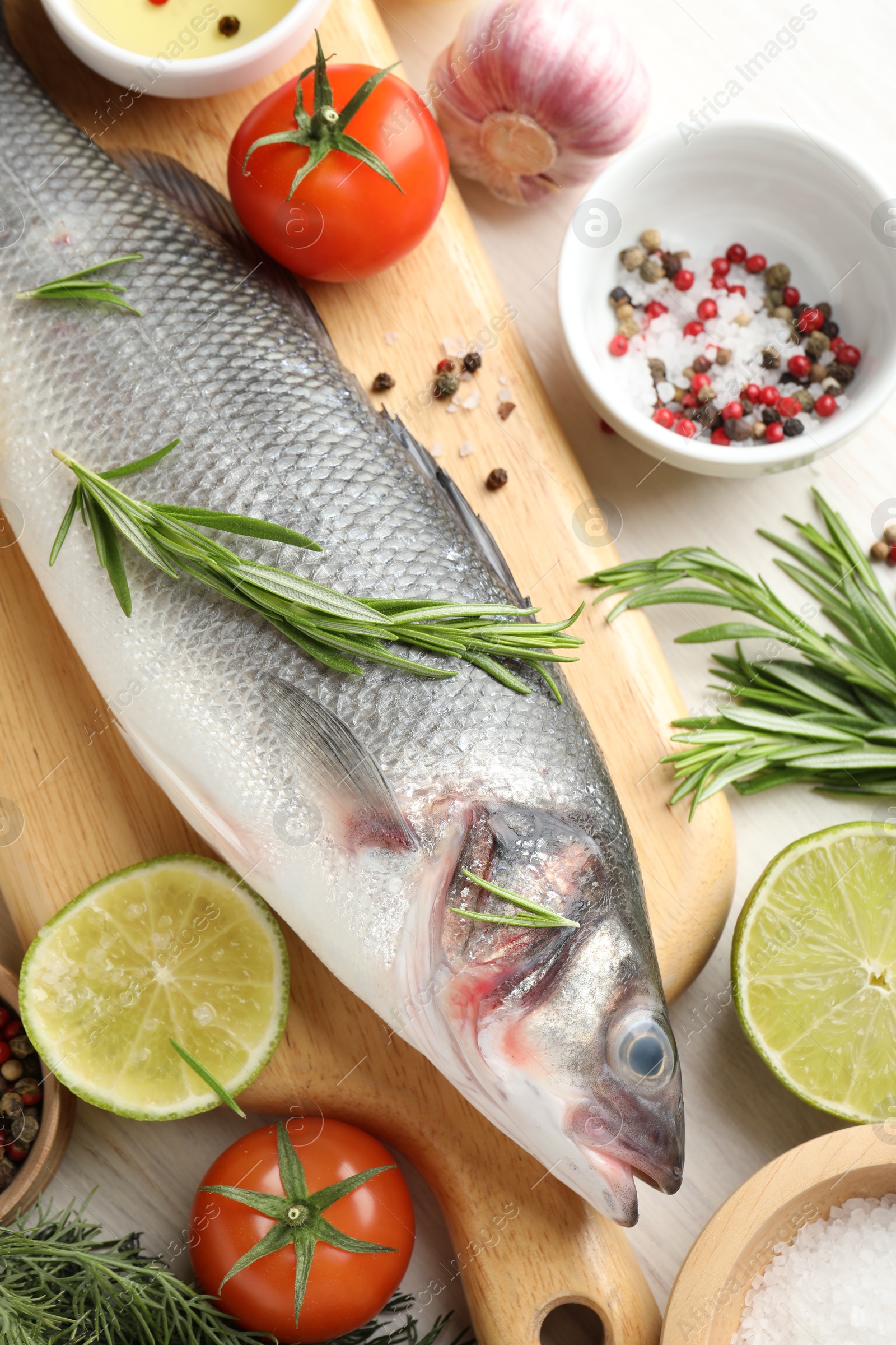 Fresh raw seabass with spices on white wooden table, flat lay. Fish and seafood delicacies Photo of Fresh raw seabass with spices on white wooden table, flat lay. Fish and seafood delicacies