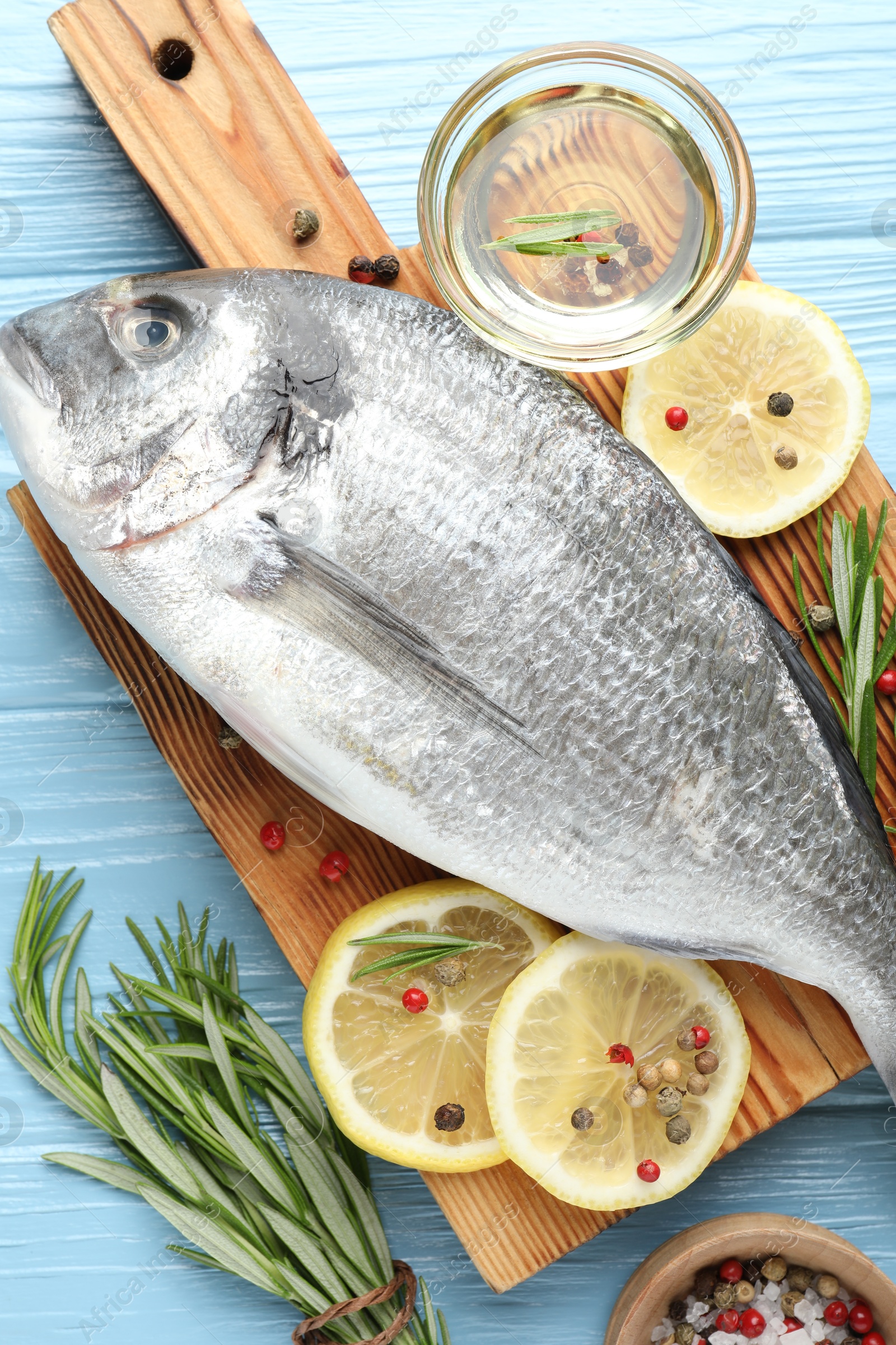 Fresh raw dourade with spices on blue wooden table, flat lay. Fish and seafood delicacies Photo of Fresh raw dourade with spices on blue wooden table, flat lay. Fish and seafood delicacies