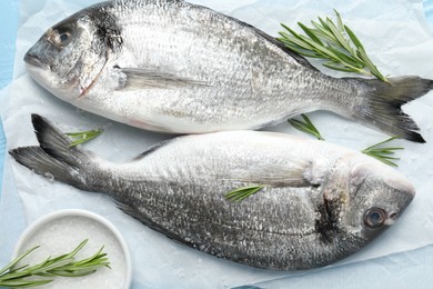 Photo of Fresh raw dourade with spices on table, closeup. Fish and seafood delicacies