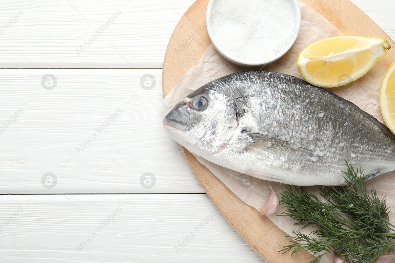 Fresh raw dourade fish with spices on white wooden table, top view and space for text. Seafood delicacies Photo of Fresh raw dourade fish with spices on white wooden table, top view and space for text. Seafood delicacies