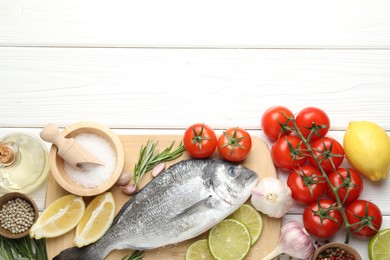 Photo of Fresh raw dourade fish with spices on white wooden table, flat lay and space for text. Seafood delicacies