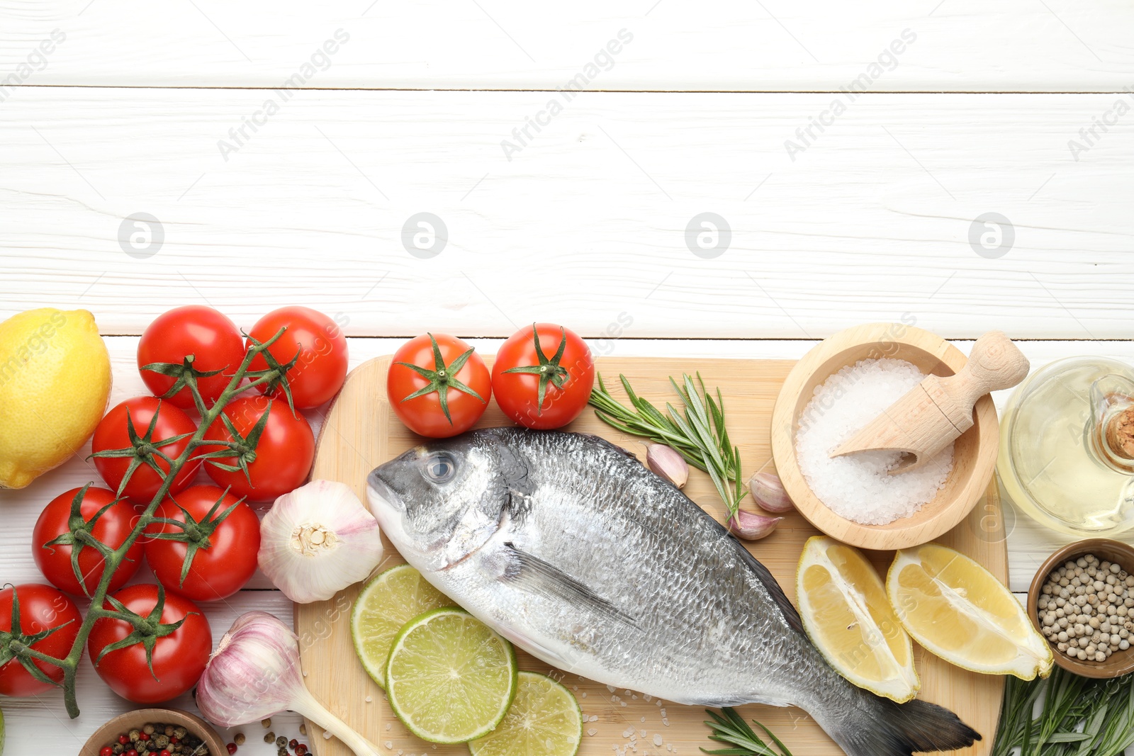 Fresh raw dourade fish with spices on white wooden table, flat lay and space for text. Seafood delicacies Photo of Fresh raw dourade fish with spices on white wooden table, flat lay and space for text. Seafood delicacies