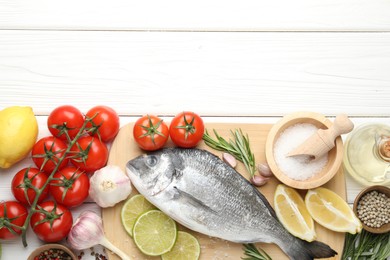 Photo of Fresh raw dourade fish with spices on white wooden table, flat lay and space for text. Seafood delicacies