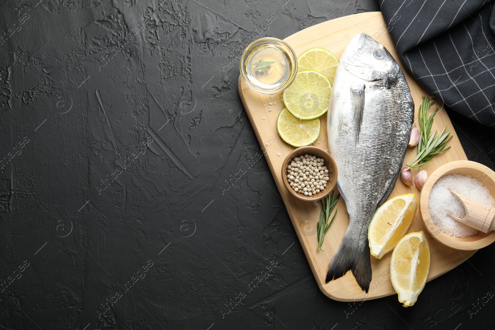 Fresh raw dourade fish with spices on black table, top view and space for text. Seafood delicacies Photo of Fresh raw dourade fish with spices on black table, top view and space for text. Seafood delicacies