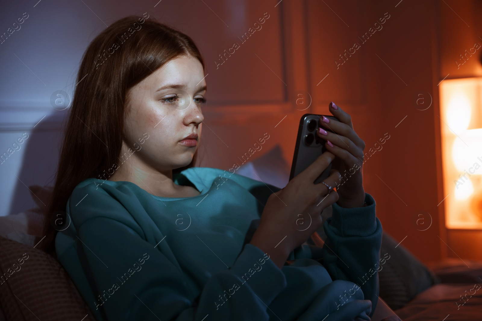Beautiful teenage girl using smartphone on bed at home Photo of Beautiful teenage girl using smartphone on bed at home