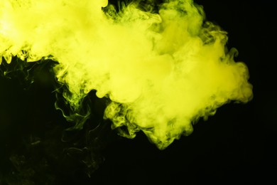 Photo of Hookah smoke in yellow light on black background, closeup