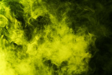 Photo of Hookah smoke in yellow light on black background, closeup