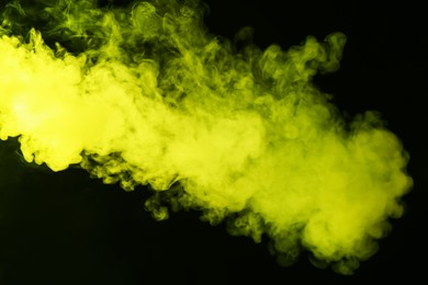 Photo of Hookah smoke in yellow light on black background, closeup