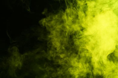 Photo of Hookah smoke in yellow light on black background, closeup