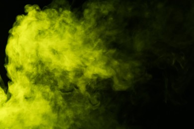 Photo of Hookah smoke in yellow light on black background, closeup