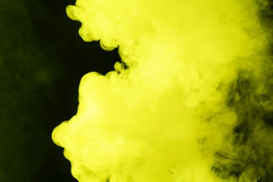 Photo of Hookah smoke in yellow light on black background, closeup