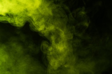 Photo of Hookah smoke in yellow light on black background, closeup